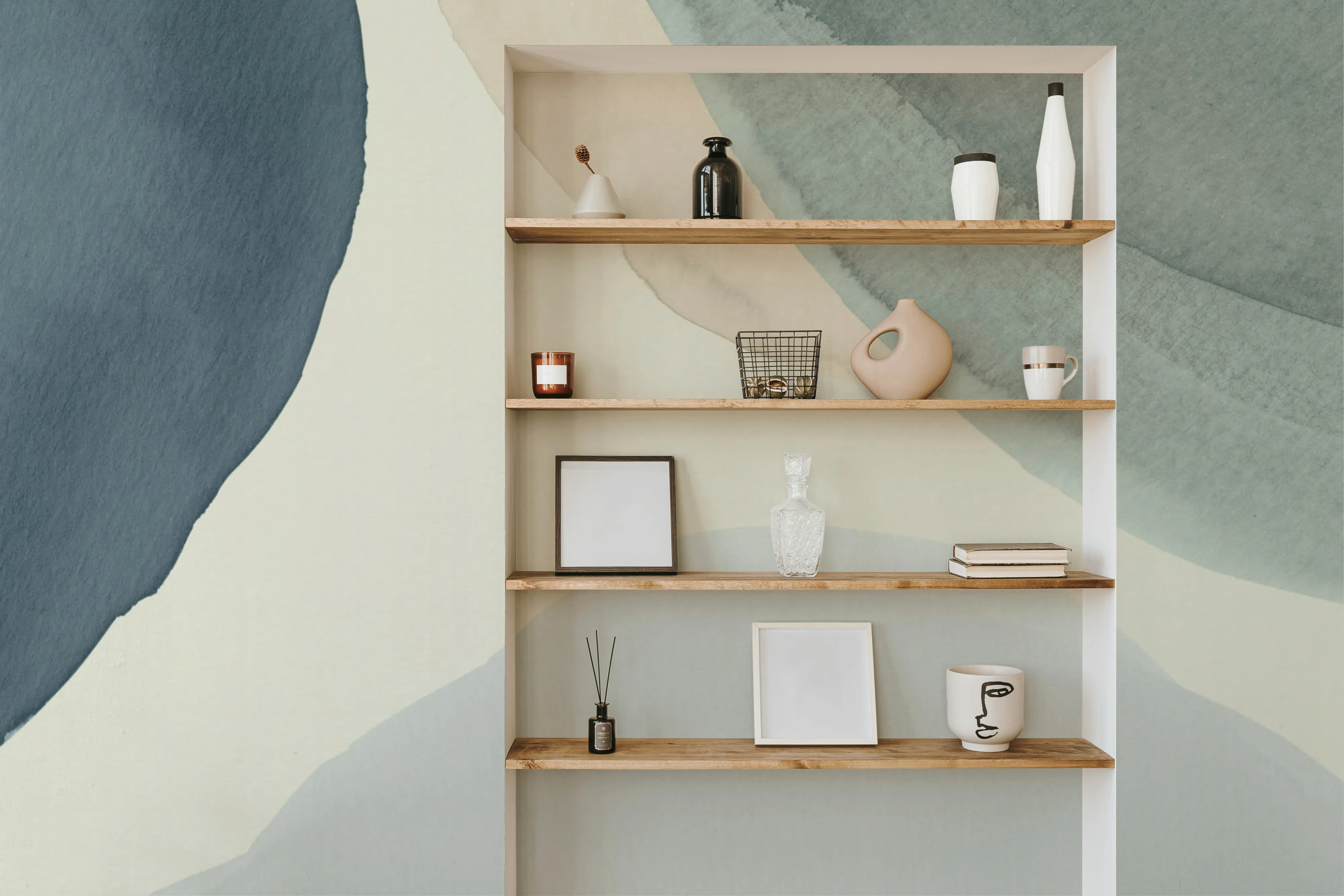 A stylish alcove with wooden shelves against a large-scale blue and beige abstract watercolor mural.