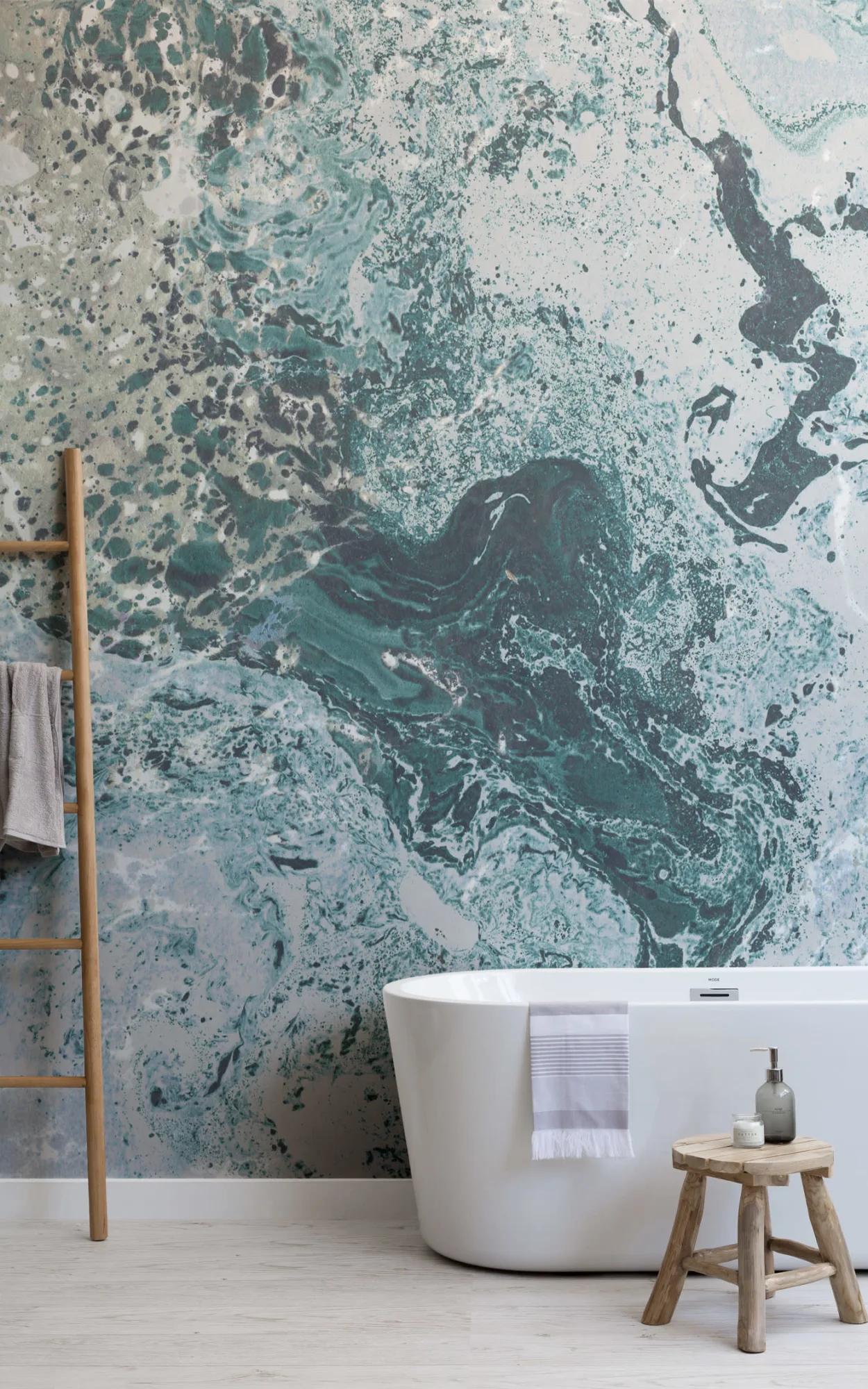 Modern bathroom with blue and white marble effect wall mural, freestanding bathtub, and wooden stool.