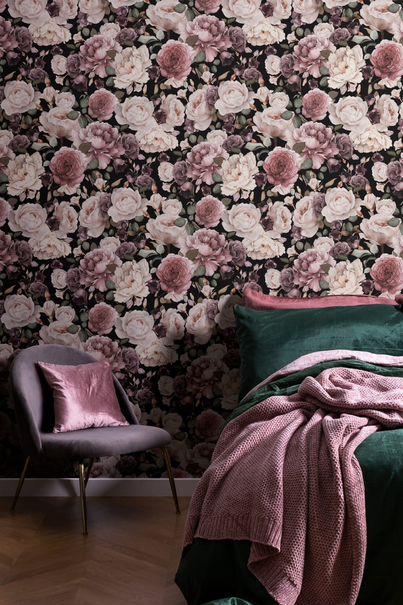 A dramatic bedroom with a dark floral wallpaper featuring blush and mauve roses, complemented by deep green bedding and soft pink accents.