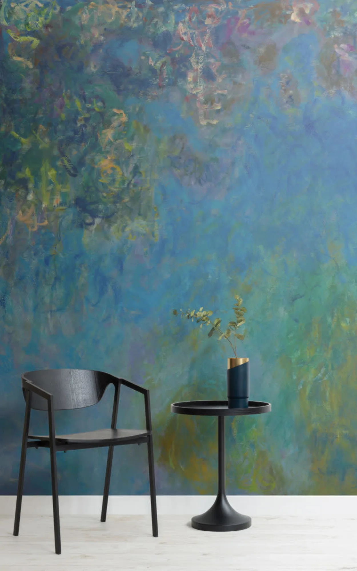 A modern minimalist setting with a sleek black chair and a matching circular table, set against a vibrant, impressionistic-style mural with lush blends of blues and greens, enhanced by a small potted plant adding a touch of nature to the space.