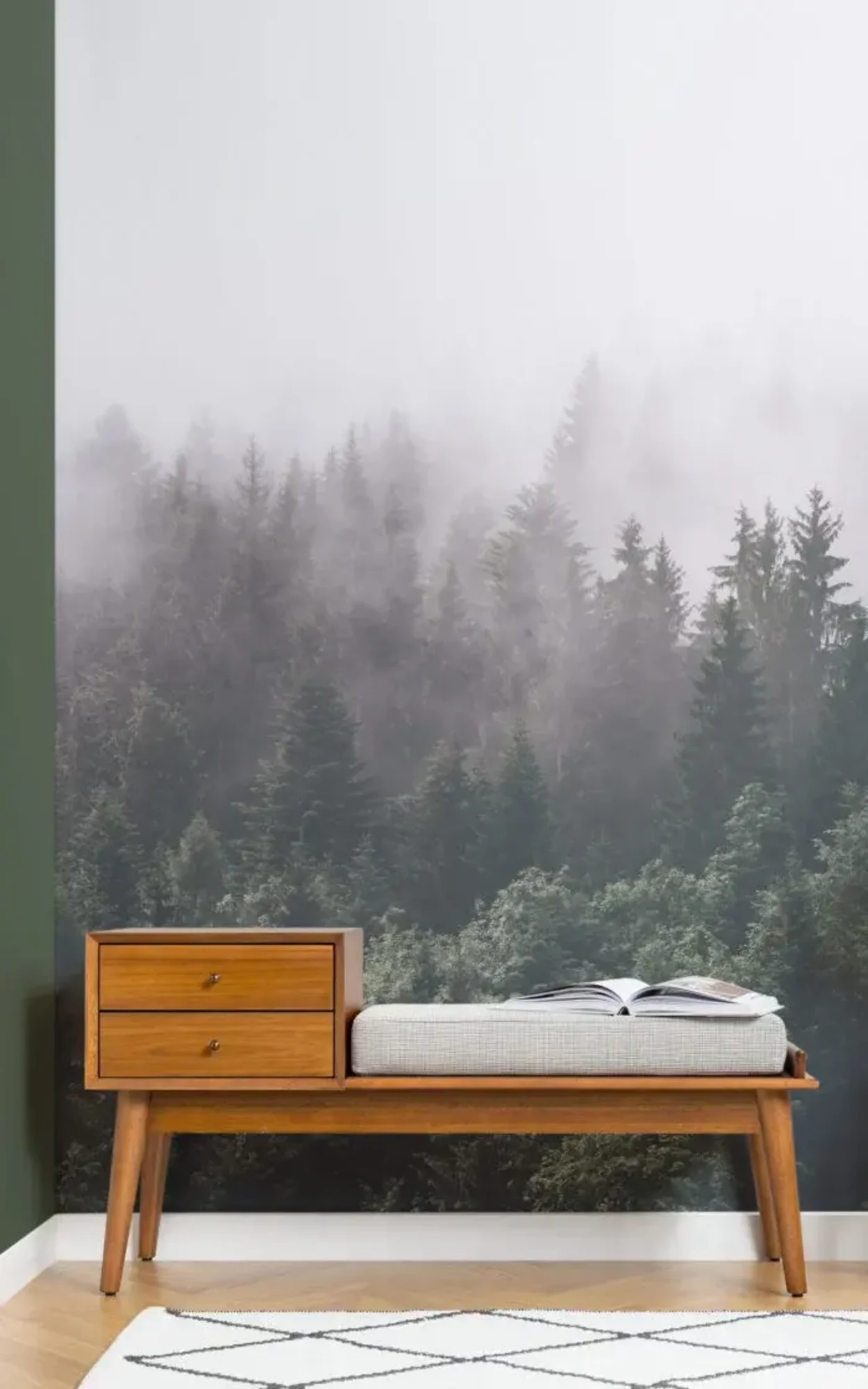 A tranquil and cozy corner features a wooden bench with a cushion and an open book, set against a dramatic mural of a misty forest, evoking a sense of calm and connection with nature. The scene is complemented by a minimalist black and white rug, enhancing the modern yet rustic aesthetic.