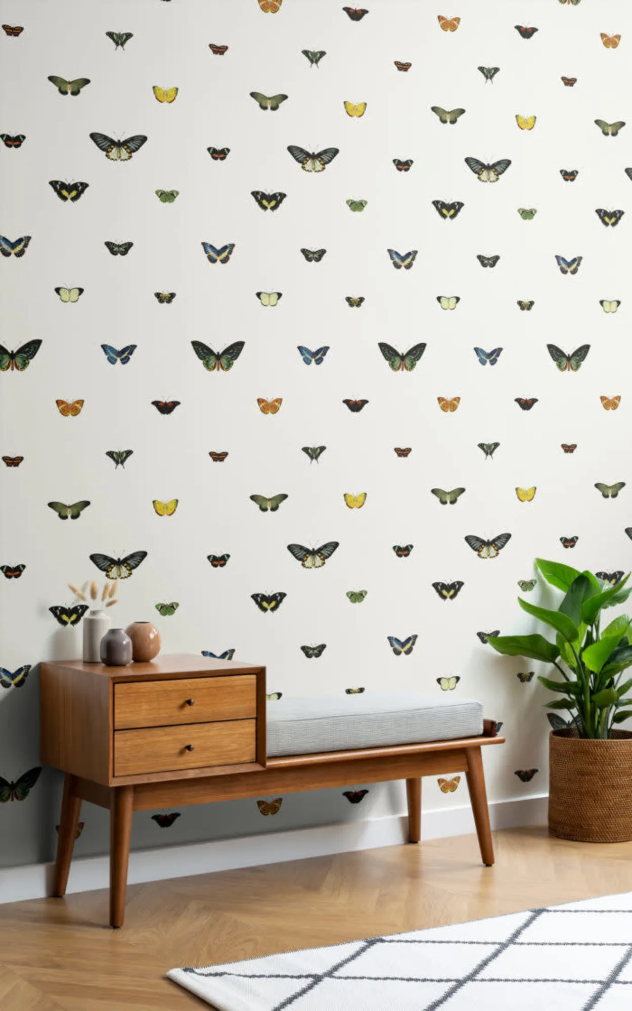 The room is brightened by a whimsical wallpaper adorned with a colorful array of butterflies, paired with mid-century modern furniture and vibrant green plants, creating a cheerful and lively space.