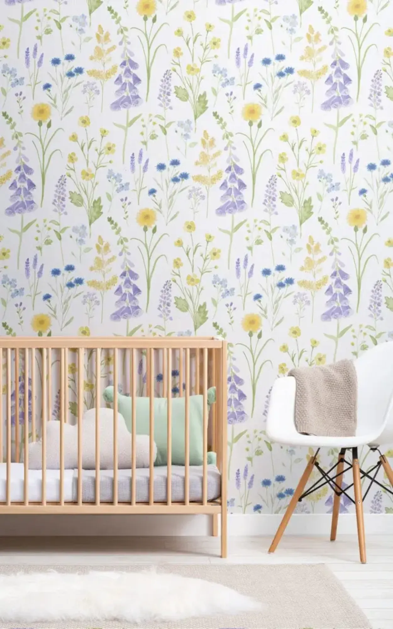 This charming nursery is adorned with a delicate, floral wallpaper featuring soft hues of yellow and purple, creating a tranquil and welcoming space for a child.