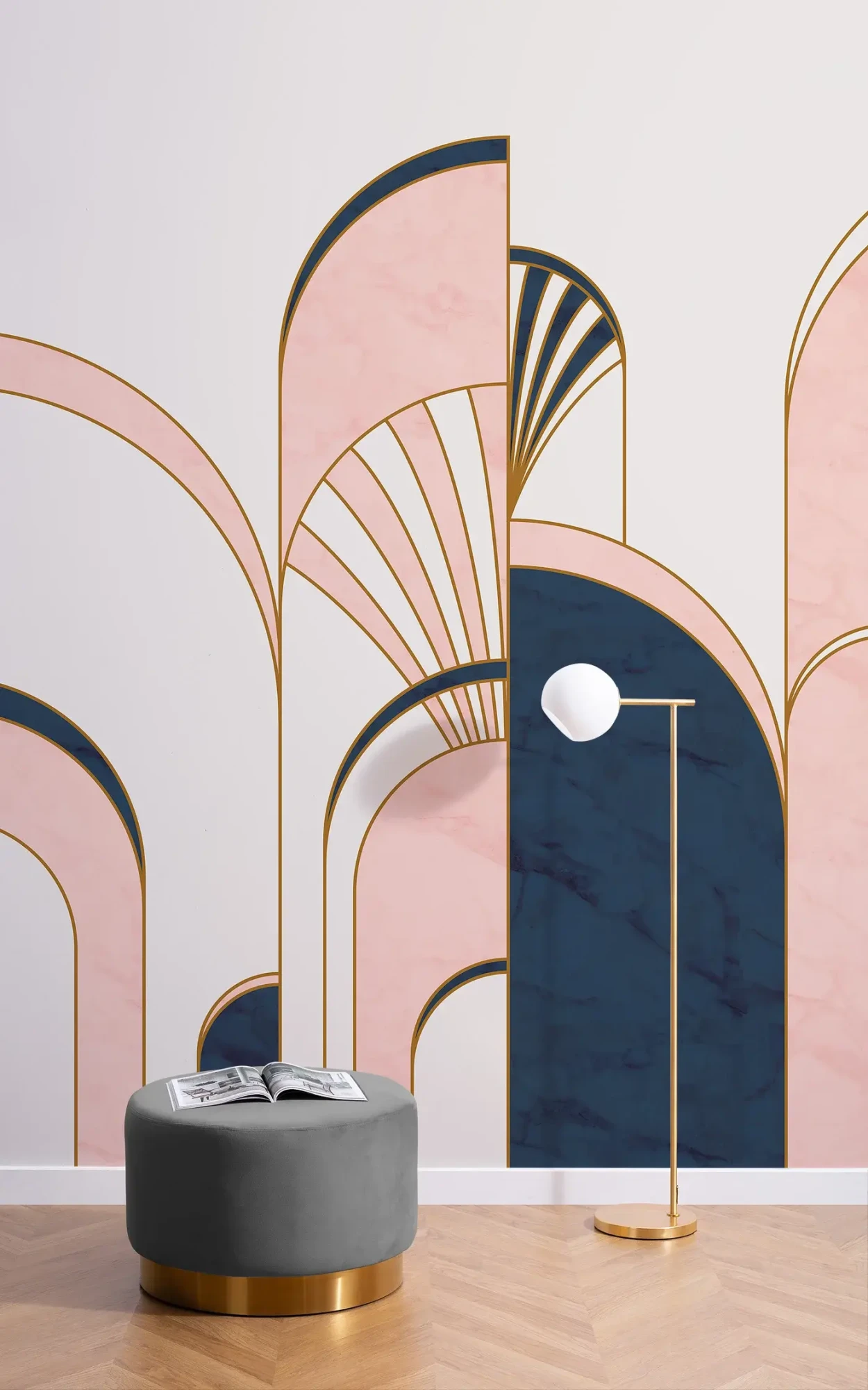 An artistic interior design featuring large, overlapping Art Deco-style arches in pink and navy blue, accented with gold lines, complemented by a dark gray ottoman and a slender floor lamp in a minimalist setting.