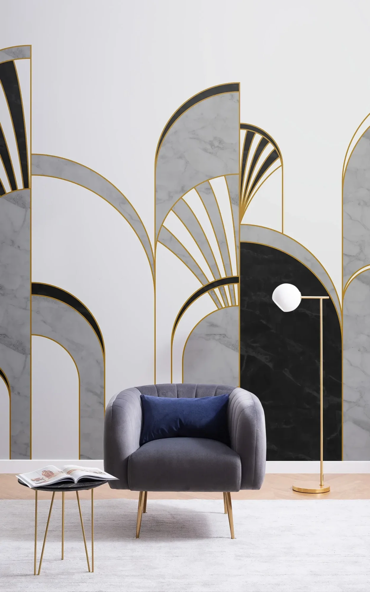 A sophisticated living room setup featuring a dark gray velvet armchair with a blue cushion, a minimalist gold floor lamp, and large decorative panels with Art Deco motifs combining gold, marble, and black elements.