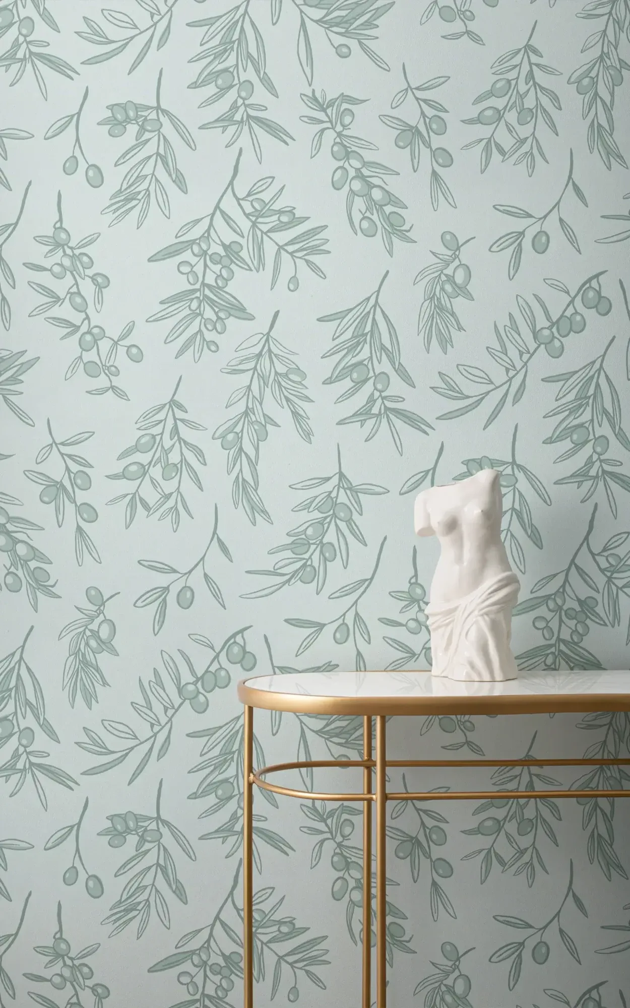 A serene interior with a light blue wallpaper adorned with a delicate olive branch pattern, featuring a classic sculpture on a golden-rimmed marble tabletop.