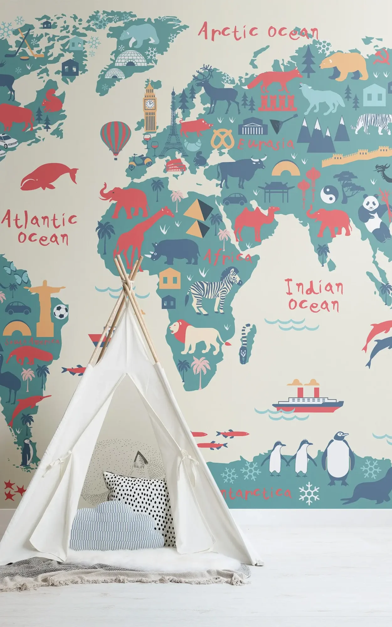 A child's play area with a white teepee featuring assorted pillows inside, set against a backdrop of a colorful world map wallpaper depicting different continents, oceans, and various cultural and animal icons.