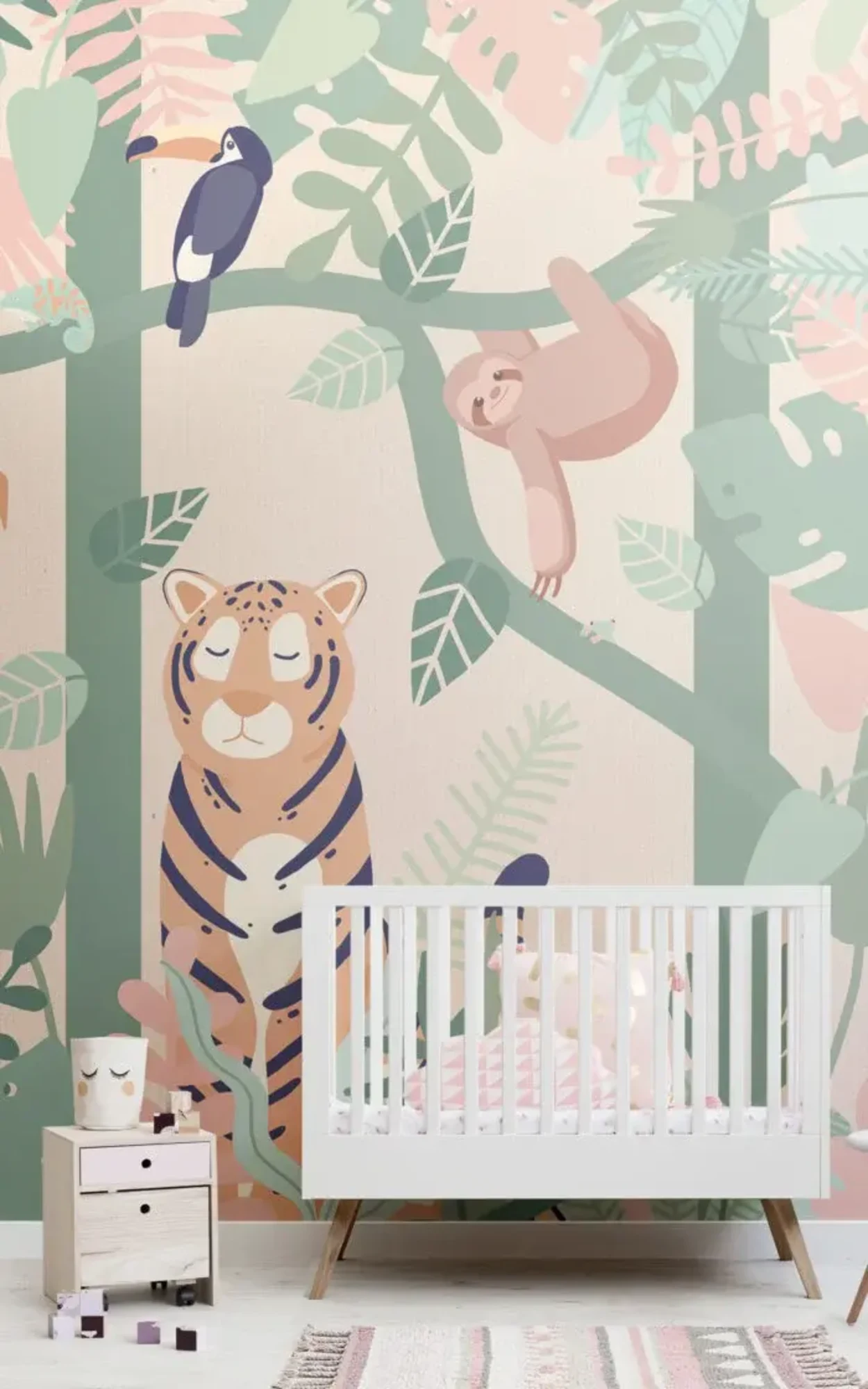  A nursery room features a white crib, a small dresser with drawers, and a playful jungle mural with illustrations of a sloth, toucan, tiger, and lush foliage on the wall behind.