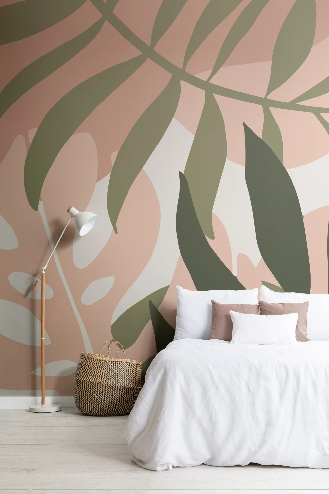 A light, airy bedroom with abstract tropical leaf murals in green and beige, paired with minimalist white bedding.