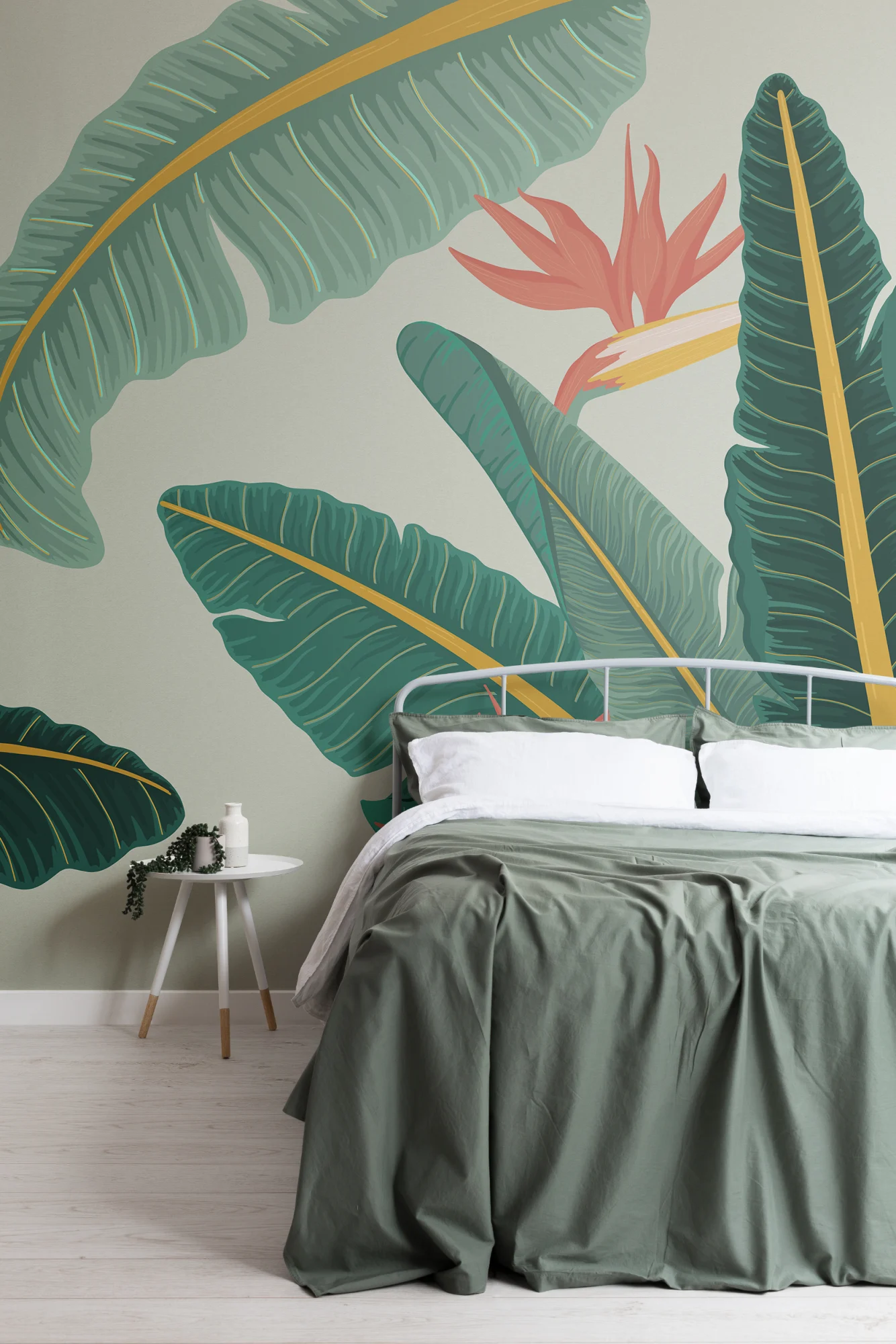 A cozy bedroom with a bold banana leaf mural, a white bed, and green bedding for a tropical touch.