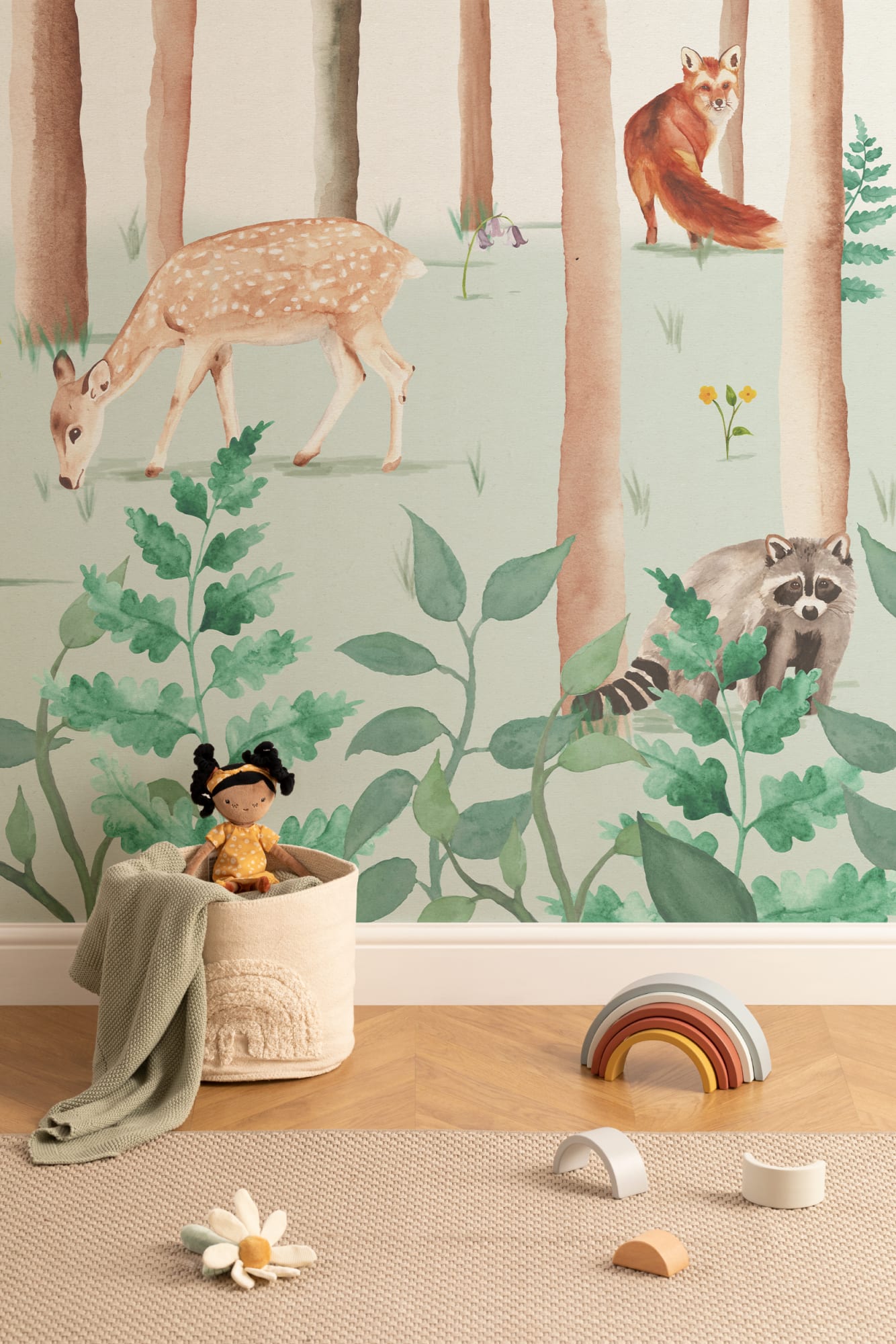 A woodland-themed nursery mural with deer, fox, and raccoon set in a forest scene.