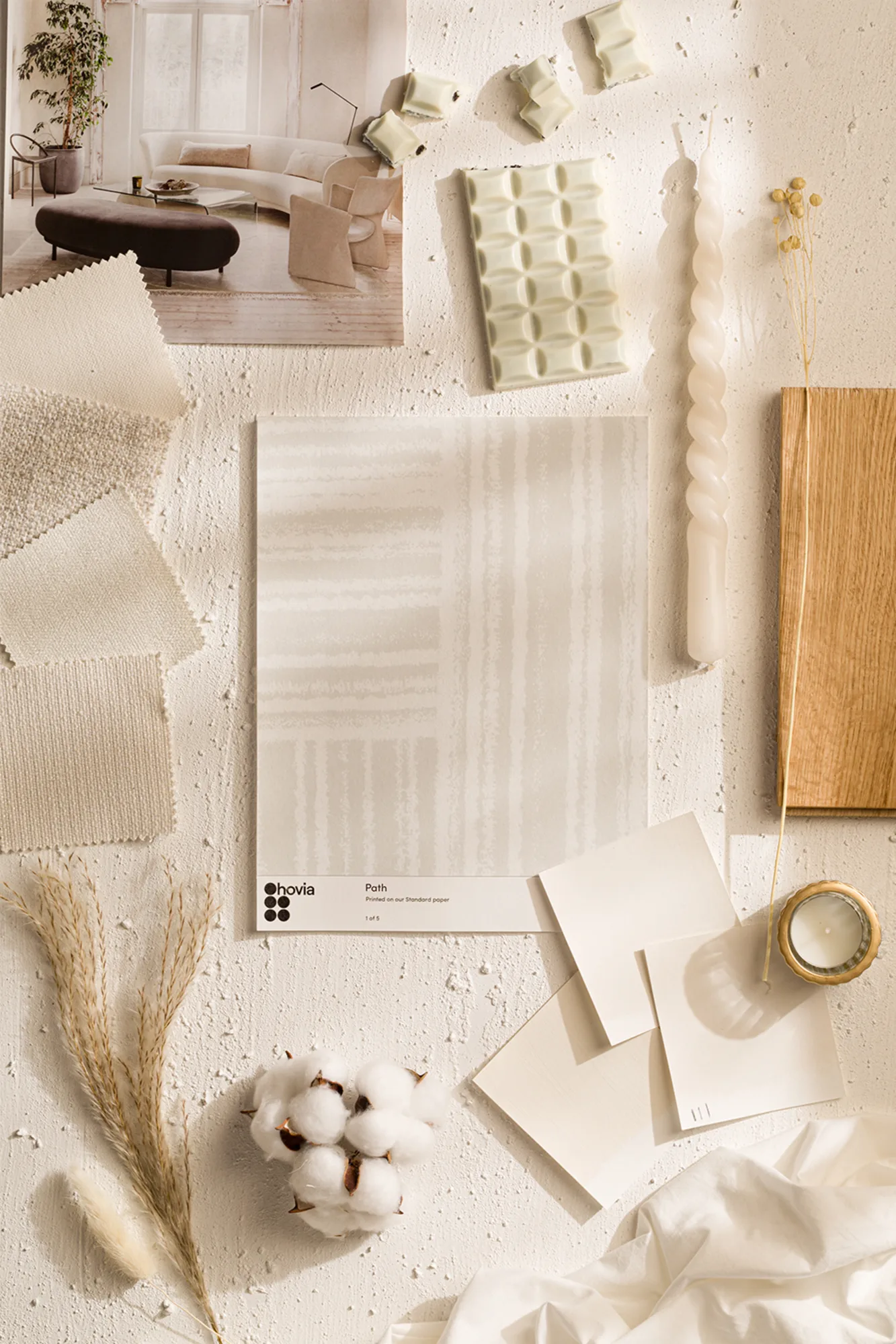 A flat lay mood board showcasing a palette of neutral colors, fabric swatches, natural textures, and design inspirations for minimalist interiors.