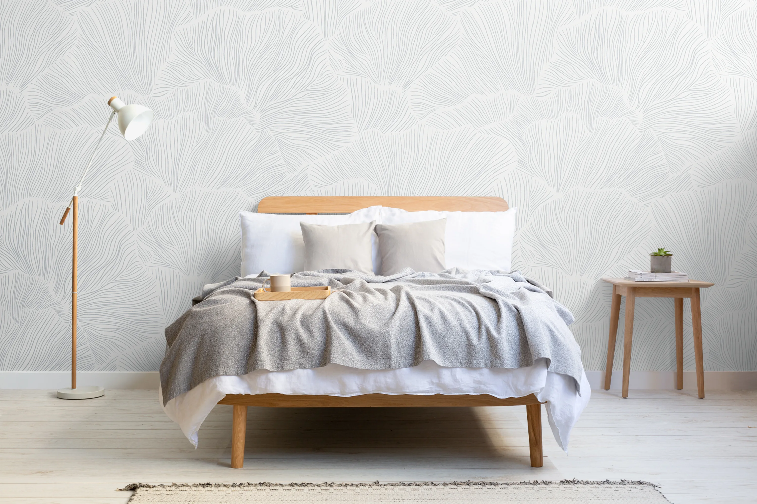 A minimalist bedroom with a white bed and pale blue mural featuring fine line details.