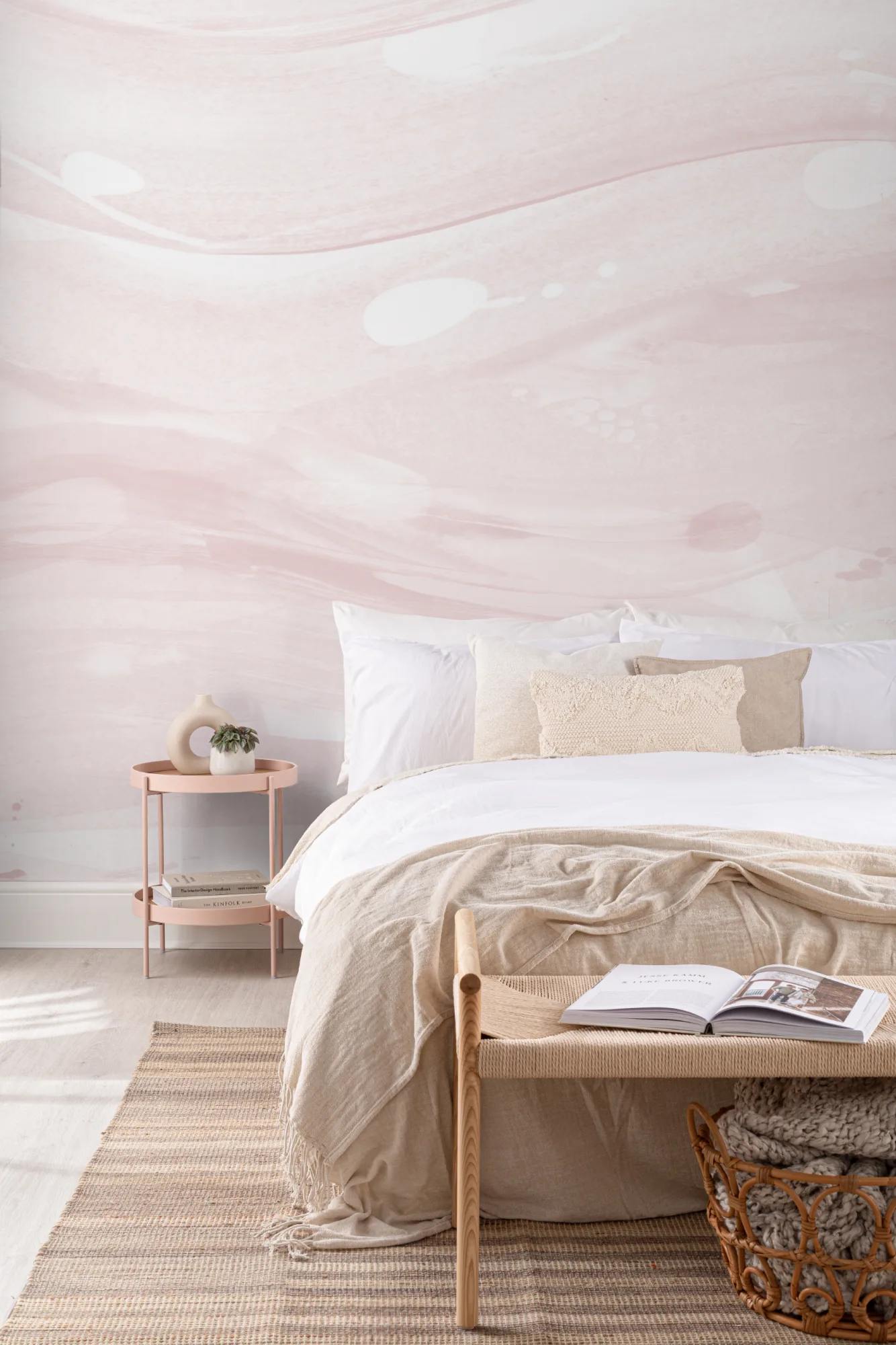 A serene minimalist bedroom with a pink abstract mural, white bedding, and soft beige accents.