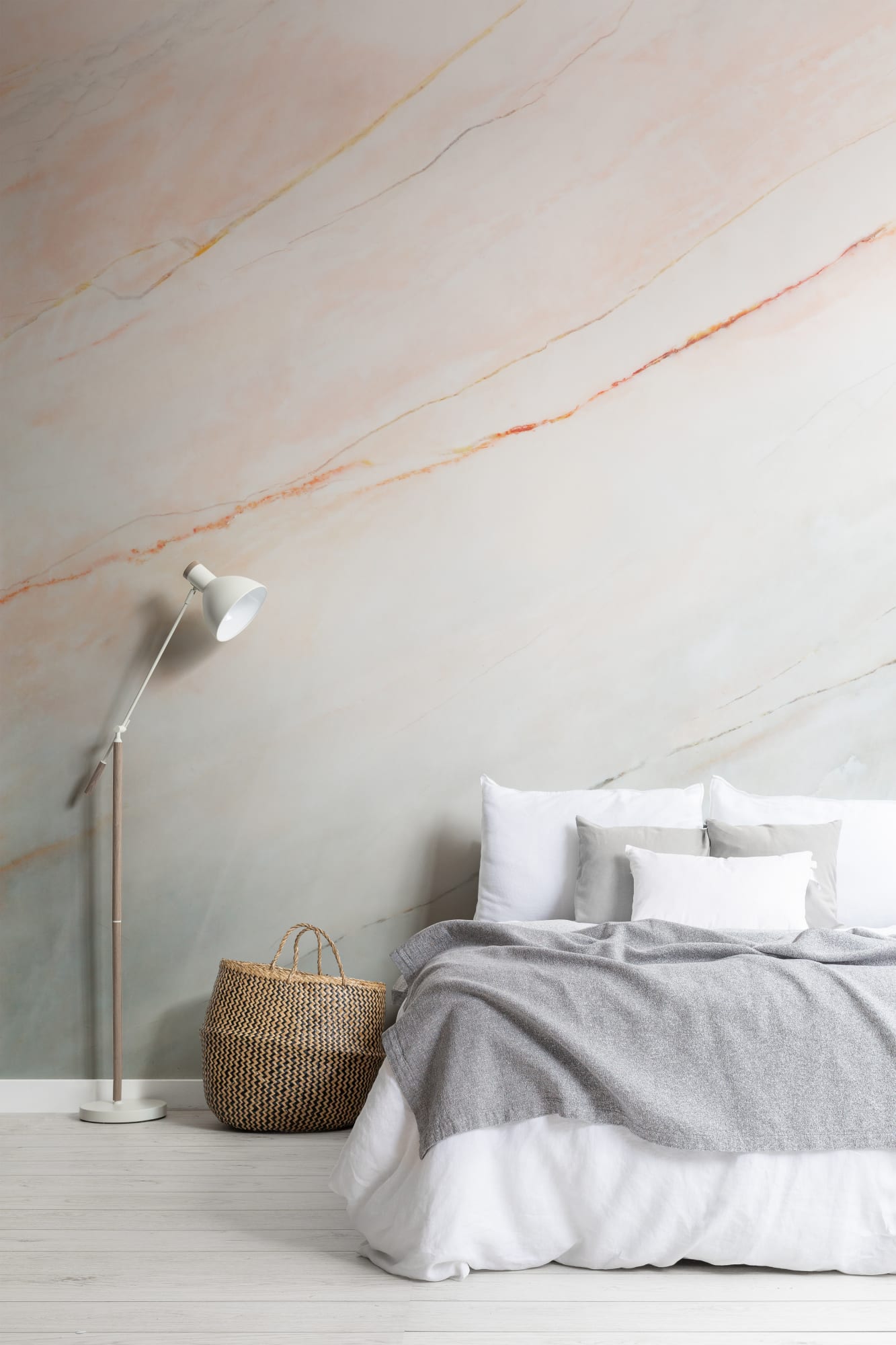 A sophisticated minimalist bedroom with a marble mural, neutral bedding, and a woven basket for decor.