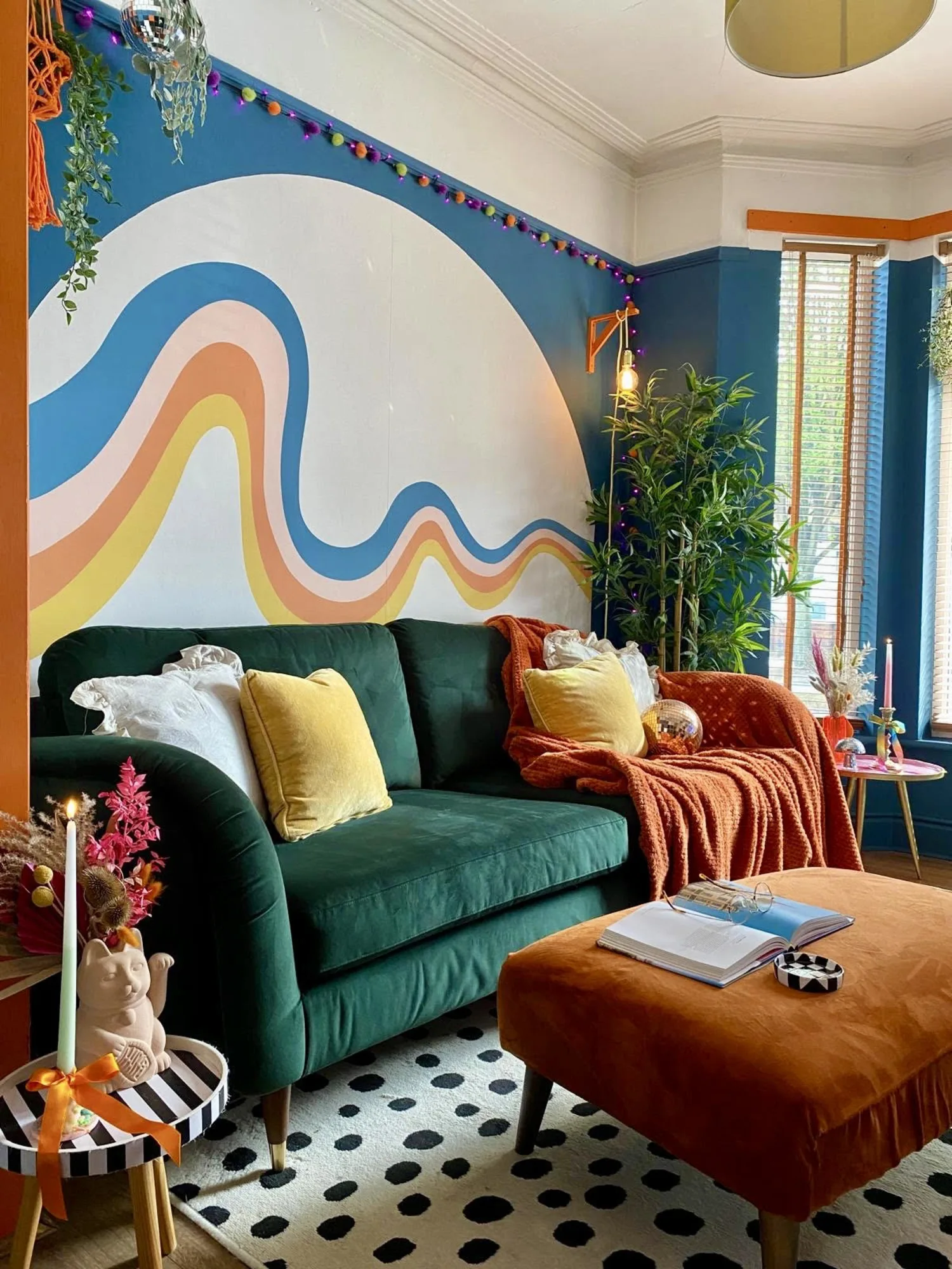 A colorful living room with a bold retro rainbow mural and vibrant furnishings.