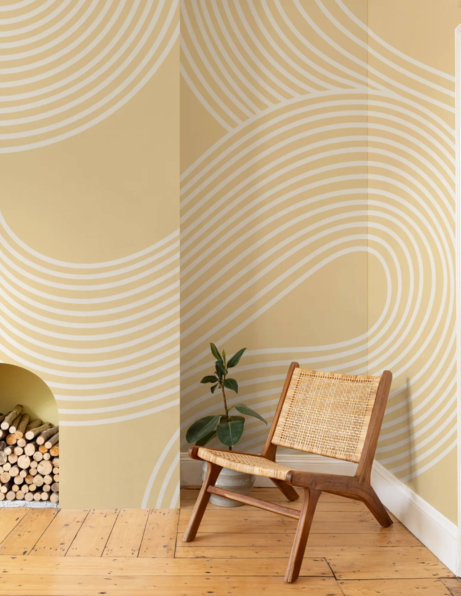 Living room with yellow and white curved line mural, wooden floors, and a woven accent chair.