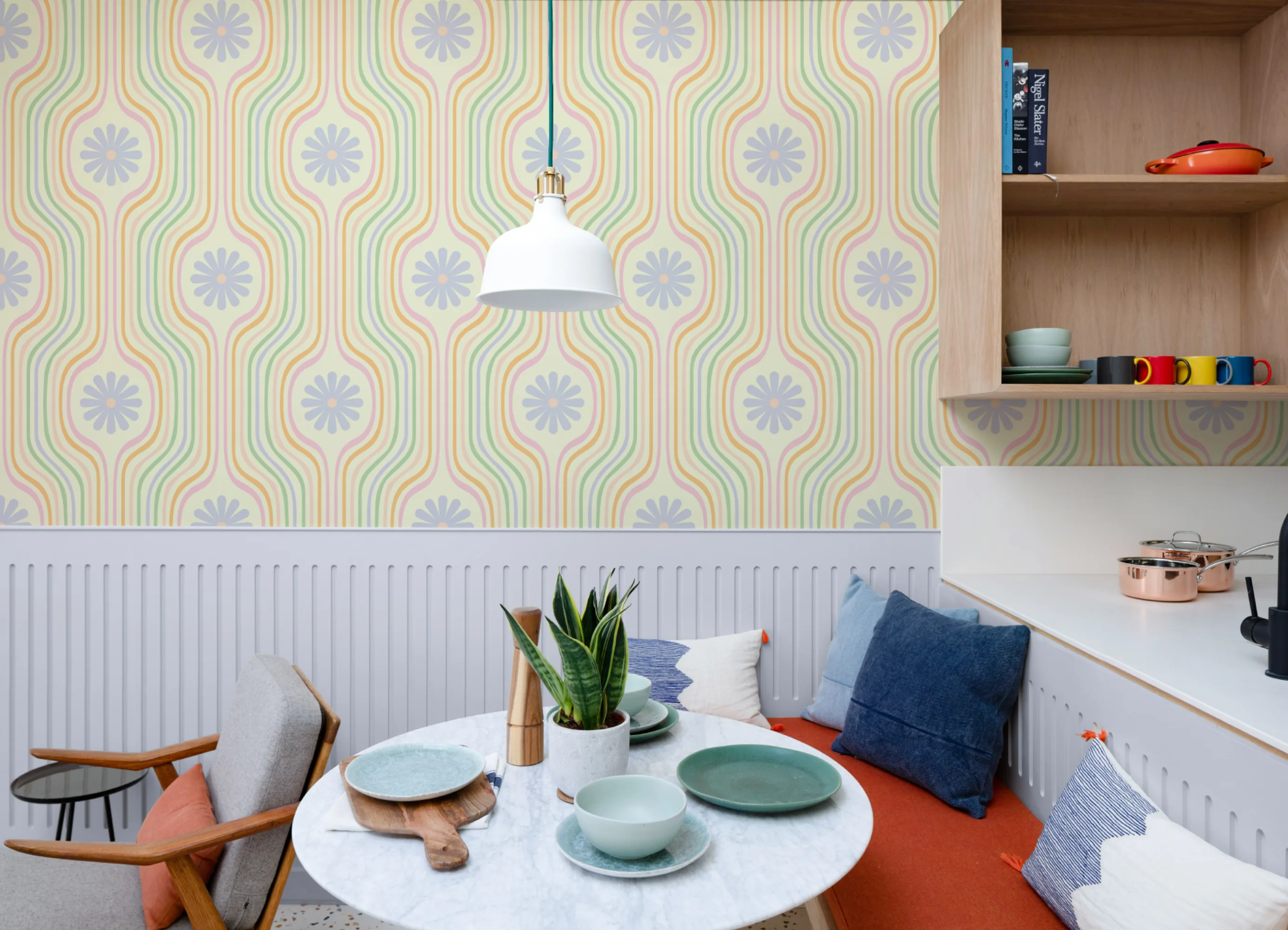 Dining area with pastel retro wallpaper featuring wavy stripes and flowers, styled with modern furniture.