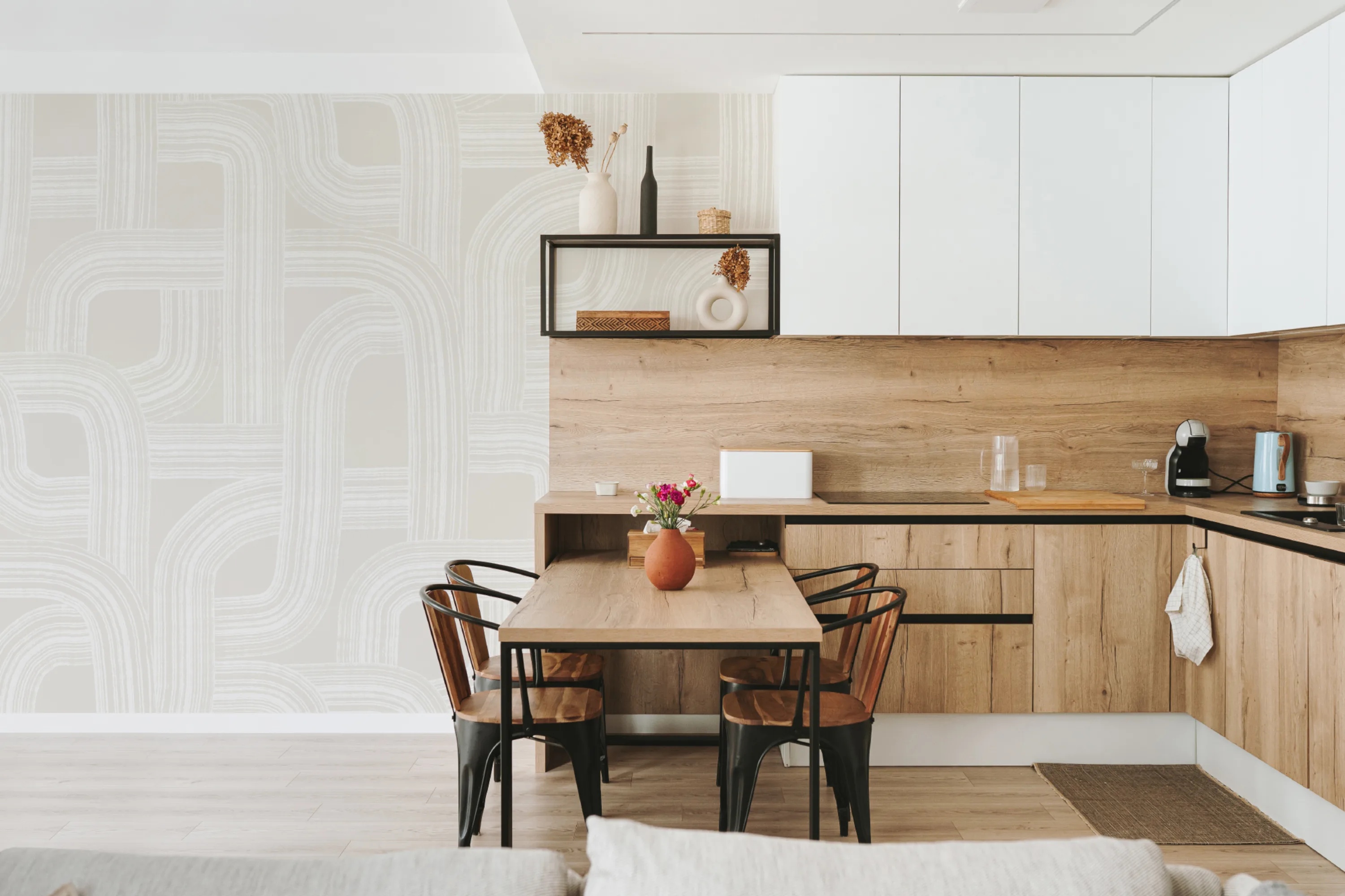 Modern kitchen with a light wood dining set and neutral abstract curved line wallpaper.