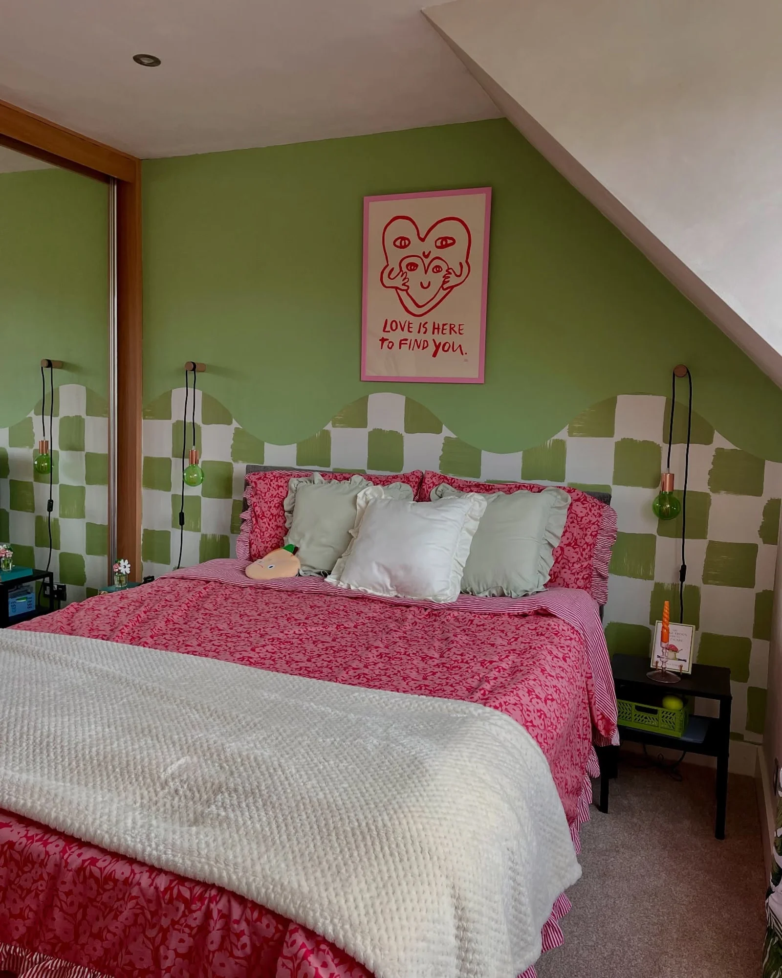 Attic bedroom with green walls, green checkerboard mural, and pink bedding.