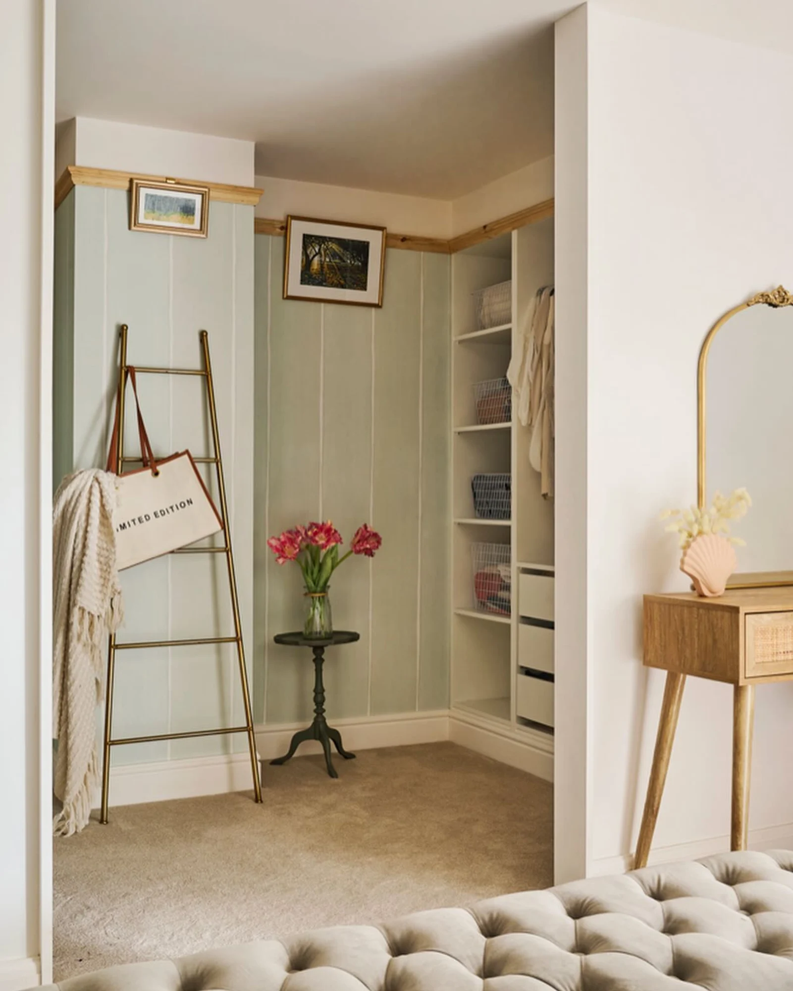 Closet nook with green striped wallpaper and decorative accents like a ladder and framed art.