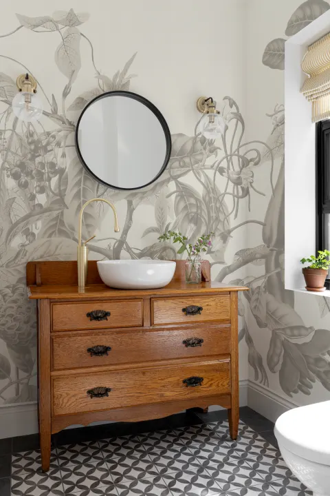 Exuberante mural de papel pintado con flores tropicales y frondosas enredaderas, de estilo botánico vintage y color gris
