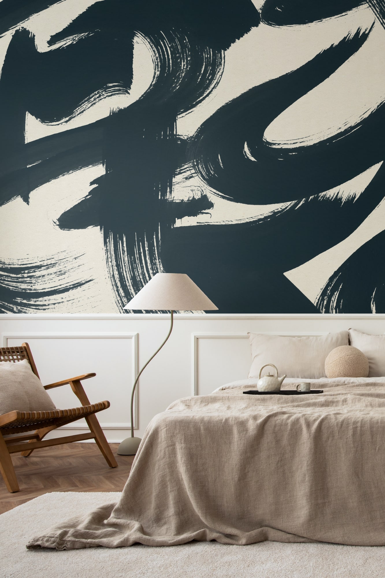 A neutral bedroom with a large black brushstroke mural on the wall behind the bed.