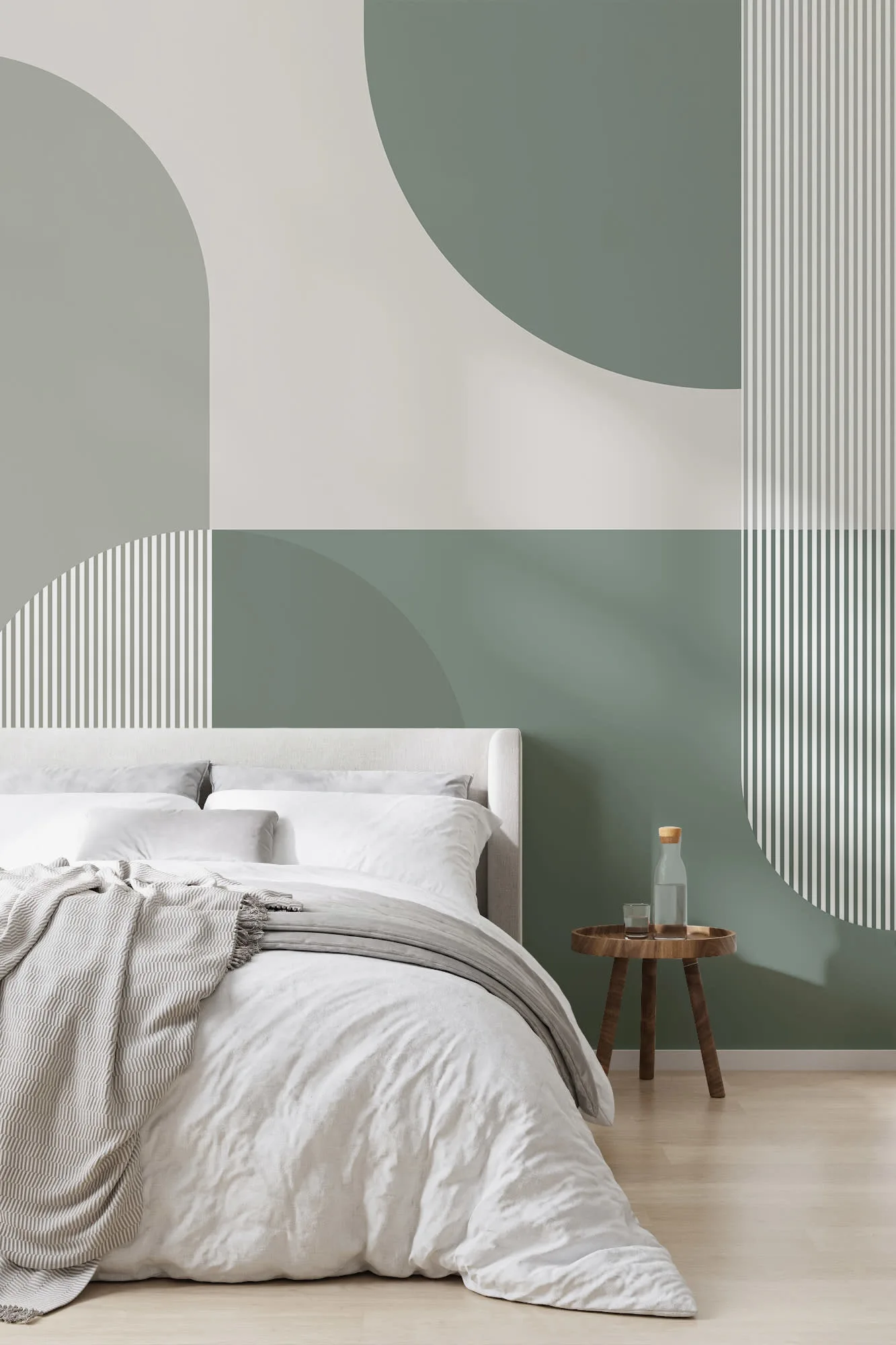 A modern bedroom with a bold geometric mural in sage green and white behind the bed.